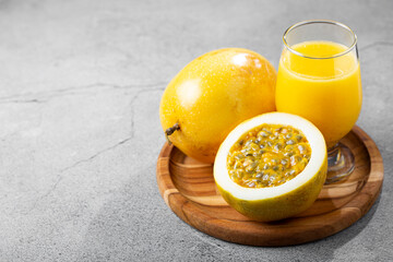 Glass with passion fruit juice and sliced ​​passion fruit on the table.