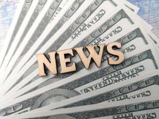 Top view wooden word with text NEWS on banknotes background.