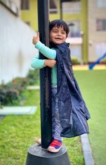 Niño abraza al poste del parque de casa alegre y timido