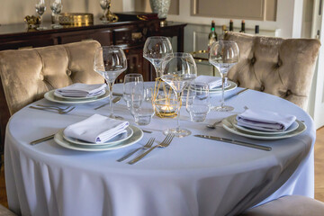 Empty table with full set of dishes in elegant restaurant