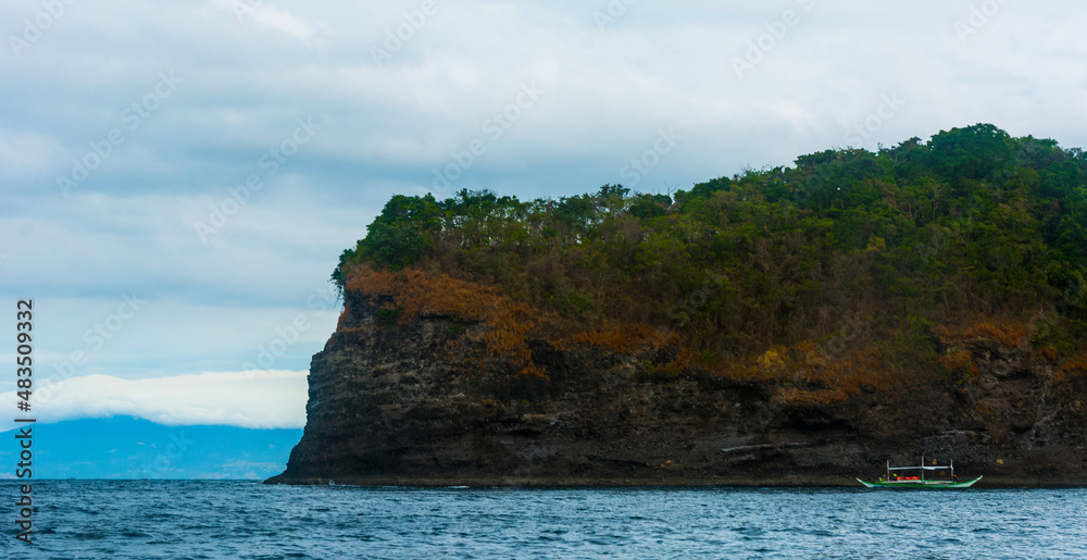 Wall mural rock island over scenic blue sea water.