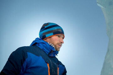 Portrait of a builder in a blue knitted hat and blue winter jacket
