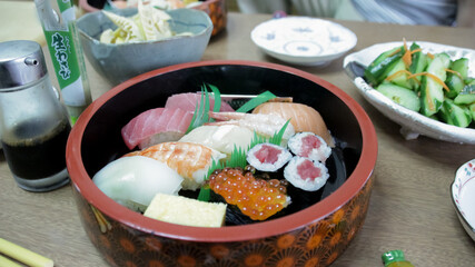 Sushi and sashimi with soya sauce on wooden table in Tokyo
