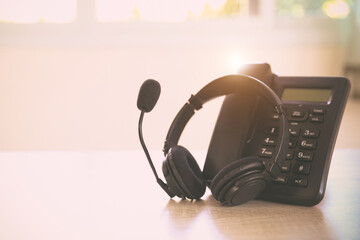 Customer service concept. Close-up headset and telephone for communication helpdesk IT support or call center and online customer services.
