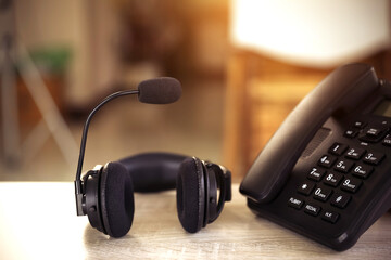 Obraz na płótnie Canvas Customer service concept. Close-up headset and telephone for communication helpdesk IT support or call center and online customer services.