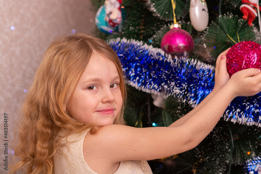 Wall mural A beautiful elegant girl near the Christmas tree in the New Year