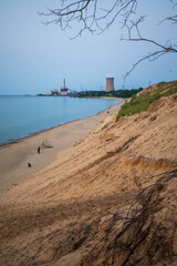 Fototapeta na wymiar Lake shore and beach at Indiana Dunes National Park in Summer. Lake Michigan with factory by the lake.