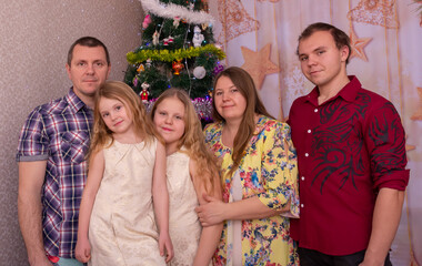 Happy family at the Christmas tree on New Year's holidays.