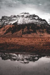Weite vertikale Aufnahme des schneebedeckten Bergplateaus, das sich im Teich in Island widerspiegelt © ANITEK MEDIA 