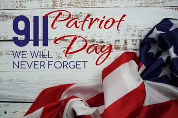Fototapeta na wymiar 911 Patriot Day We will never forget message with American flag on wooden background