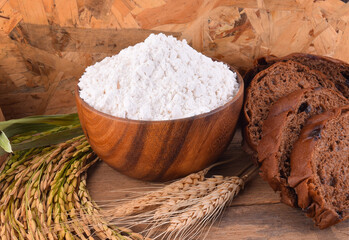 All purpose wheat flour in bowl on wooden background