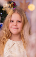 A beautiful elegant girl near the Christmas tree in the New Year