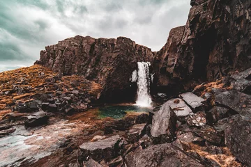 Weitwinkelaufnahme des versteckten Wasserfalls Folaldafoss, der in einen blaugrünen Pool in Island strömt © ANITEK MEDIA 