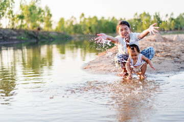 Fototapeta premium happy family Mother and little daughter playing in the water on the beach on a sunny day.