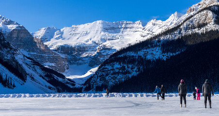 Tourists skating on Lake Louise winter ice skating rink. Banff National Park, Canadian Rockies. Alberta, Canada.