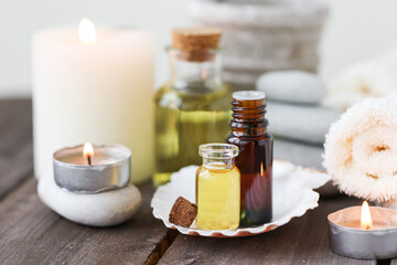 Fototapeta na wymiar Assortment of natural oils in glass bottles on wooden background. Concept of pure organic ingredients in cosmetology. Bath accessoiries, atmosphere of harmony, relax. Close up macro. Healthy lifestyle