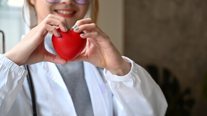 Cardiologist holding red heart shape in hand. Healthcare and medical concept.