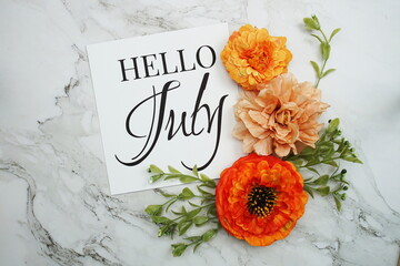 Hello July text with orange flower bouquet on marble background © may1985
