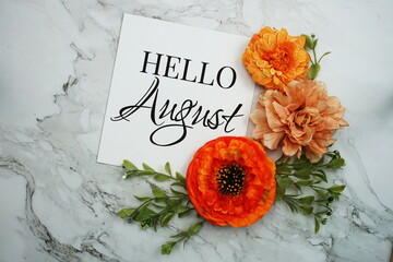 Hello August text with orange flower bouquet on marble background