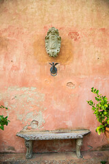 Fountains, terracotta walls and tall trees of a Tuscan villa, Italy