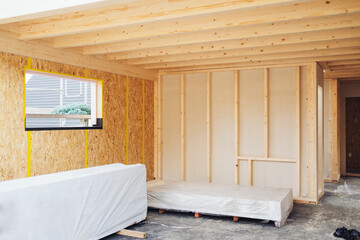 Interior of a wooden home under construction with chipboard wall