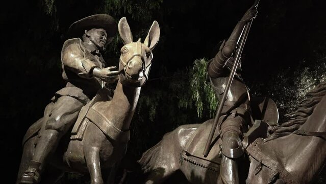 Statue of Mexican soldiers riding a horse and a donkey at night 