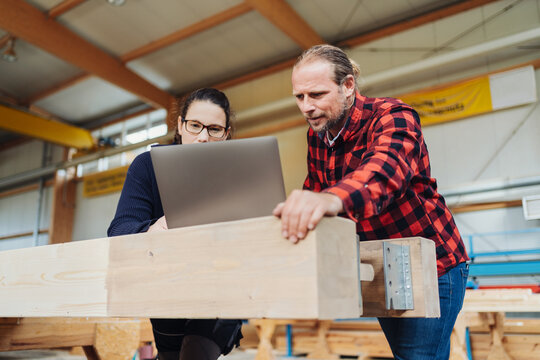 Two co-workers in a woodworking factory having a discussion