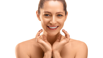 Skin care concept - close-up portrait of a 40 years old smiling woman looking at cameraand touching...