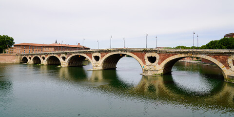Fototapeta na wymiar Pont Neuf in Toulouse in panoramic view of new brick bridge pink stone