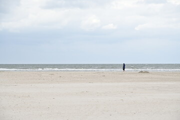 Fototapeta na wymiar St. Peter Ording Strand mit einem Mann am Meer