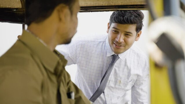 Rack focus shot, passanger negotiation for ride or travel with auto rickshaw driver - concept of transportation, communication and commutation service
