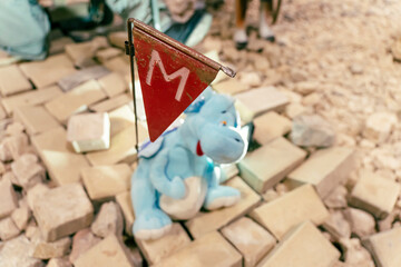 booby-trapped children's soft toy on the rocks. A dangerous trap for soldiers in war. Terrorist threat - obrazy, fototapety, plakaty