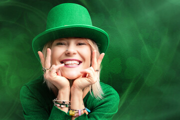 St. Patrick's Day leprechaun model girl on green magic background with shamrock leaves