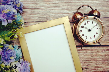 Empty space for copy with alarm clock and flower decoration on wooden background