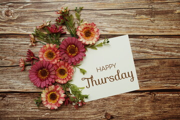 Happy Thursday typography text with flowers on wooden background