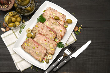 Sliced Traditional French terrine covered with bacon on dark wooden background
