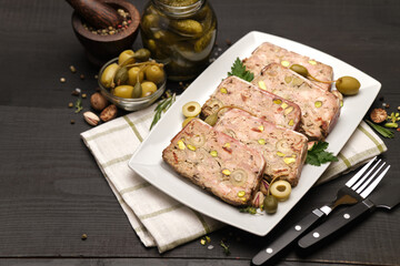 Sliced Traditional French terrine covered with bacon on dark wooden background