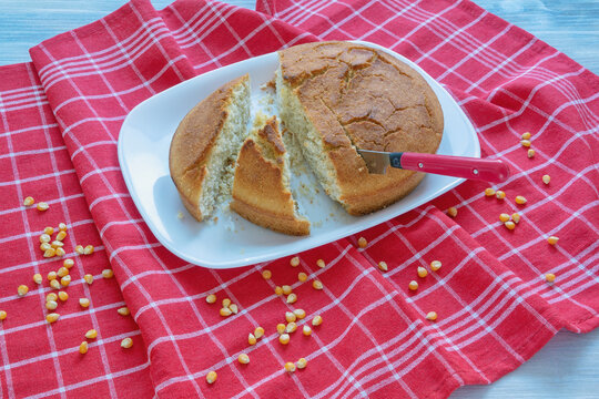 Slices of cornbread on white plate and corn grains