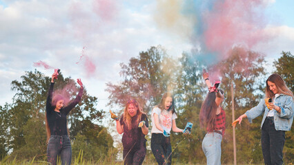 Cheerful girls toss up multi-colored powder. Holi holiday.