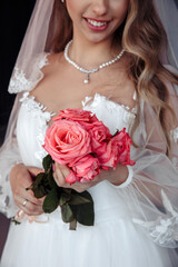 The bride is holding a bouquet of red roses. Bride morning. Beautiful wedding bouquet.