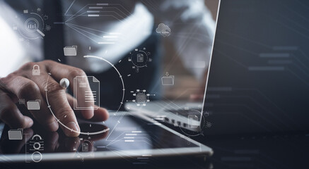 Document Management System (DMS) being setup by IT consultant working on laptop computer in office. Software for archiving, searching and managing corporate files