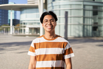 Happy asian Student. Guy smiling at camera outdoors on campus of university - obrazy, fototapety, plakaty
