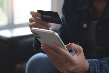Young woman hands holding credit card, using smart mobile phone for digital banking, internet payment, online shopping via mobile banking app, financial technology, E-commerce
