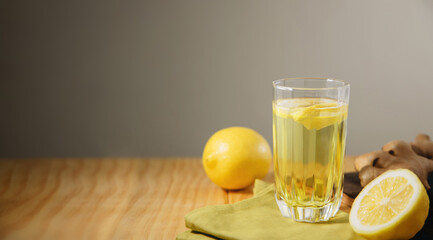 Glass of Infusion Ginger lemon drink. Organic and Healthy Lifestyle. Fresh Water with lemon Sliced. present on Table with Natural light. Seasonal Beverage