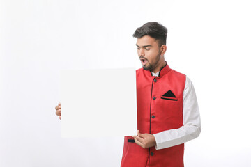 Indian man holding white board, promoting offers on festival season while wearing traditional cloths, standing over white background.