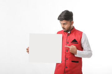 Indian man holding white board, promoting offers on festival season while wearing traditional cloths, standing over white background.