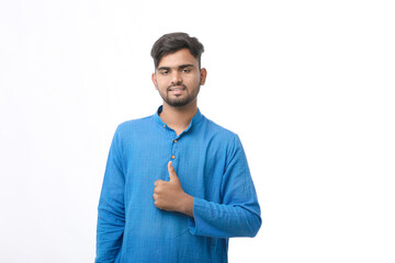 young indian man in traditional wear and showing thumps up on white background.