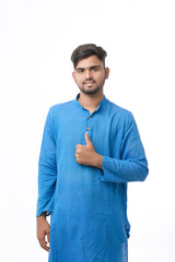 young indian man in traditional wear and showing thumps up on white background.