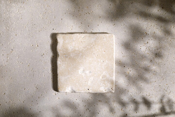 Travertine stone display flat lay podium on biege background and eucaliptus shadow. Product...