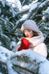 Portrait of pretty girl in snowy pines. Winter portrait. Vertical frame.